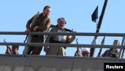 Para relawan dan pasukan Peshmerga siaga dengan senjata mereka di utara Kirkuk, Irak hari Senin (16/10). 