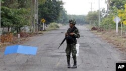 A Thai soldier mans a razor-wire roadblock close to the Thai-Cambodia border, shortly before cross-border fighting resumed for a third day, April 24, 2011.