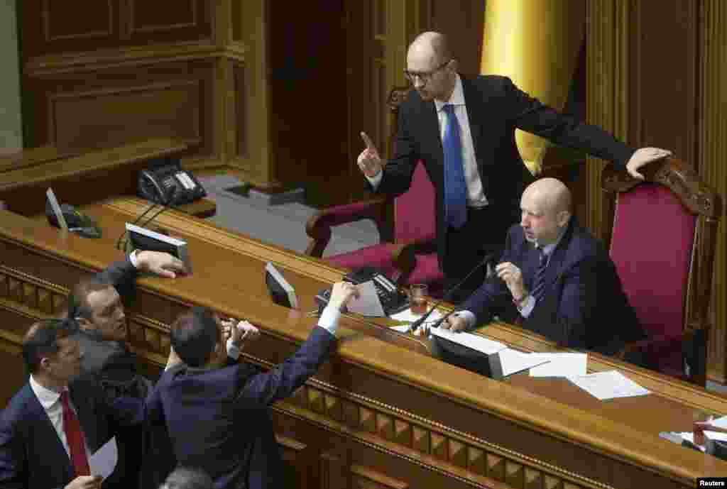 Ukrainian Prime Minister Arseniy Yatsenyuk and acting President Oleksander Turchinov talk to deputies as they attend a parliament session in Kyiv, March 27, 2014. 