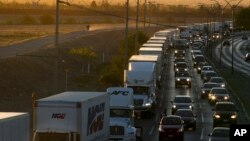 FILE- In this April 9, 2019, file photo, trucks wait to cross the border with the U.S. in Ciudad Juarez, Mexico. 