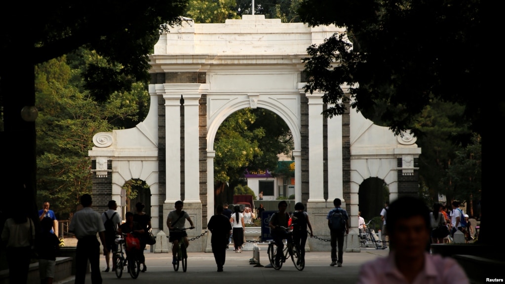 People walk near the gate of Tsinghua University in Beijing, China, July 27, 2016.