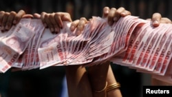 3月28日，泰國反政府抗議者手舉準備捐出泰銖，作為支持反政府素貼。