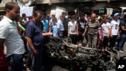 FILE - Citizens inspect the scene after a car bomb explosion at a crowded outdoor market in the Iraqi capital's eastern district of Sadr City, Iraq, May 11, 2016. 