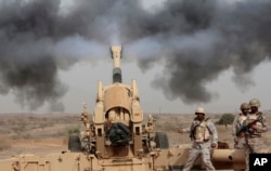 FILE - In this April 20, 2015 file photo, Saudi soldiers fire artillery toward three armed vehicles approaching the Saudi border with Yemen in Jazan, Saudi Arabia.