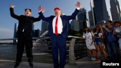 Howard, an Australian-Chinese impersonating North Korean leader Kim Jong-un, and Dennis Alan, impersonating U.S. President Donald Trump, meet at Merlion Park in Singapore, June 8, 2018. 