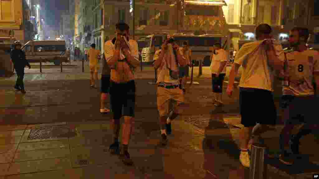 Des fans courent dans les rues de Marseille, après que la police a tiré des gaz lacrymogènes, le 11 juin 2016.