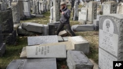 Rabbi Joshua Bolton of the University of Pennsylvania's Hillel center surveys damaged headstones at Mount Carmel Cemetery, Feb. 27, 2017, in Philadelphia.