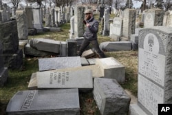 Rabbi Joshua Bolton of the University of Pennsylvania's Hillel center surveys damaged headstones at Mount Carmel Cemetery, Feb. 27, 2017, in Philadelphia.