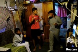 Fabiana Silva and her sons Brian, 8, left, and Breno, 14, have breakfast inside their house in Moinho favela, in Sao Paulo, Brazil, July 6, 2017.