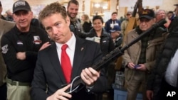 FILE - Then-Republican presidential candidate Sen. Rand Paul, R-Ky., handles a AR-15 style rifle as he meets with customers during a campaign stop at a gun show at Bektash Shrine Center in Concord, Jan. 23, 2016.