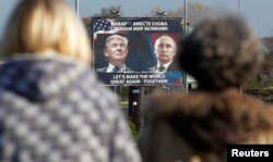 FILE - A billboard showing a pictures of U.S. president-elect Donald Trump and Russian President Vladimir Putin is seen through pedestrians in Danilovgrad, Montenegro, Nov.16, 2016.