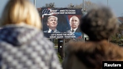 FILE - A billboard showing a pictures of then-U.S. president-elect Donald Trump and Russian President Vladimir Putin is seen through pedestrians in Danilovgrad, Montenegro, Nov.16, 2016.