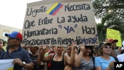 Venezuelans in Colombia protest the government of Venezuela and its blocking of humanitarian aid in Cucuta, Colombia, Feb. 12, 2019. The sign reads, "Urgent. The entry of humanitarian help is needed now. There are Venezuelans at risk of dying."