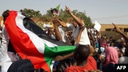 Sudanese protesters wave their national flag and chant slogans during an anti-government demonstration in the capital Khartoum's twin city of Omdurman on Jan. 31, 2019. 