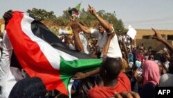 Warga Sudan yang menggelar unjuk rasa mengibarkan bendera nasional dan menyerukan slogan-slogan anti-pemerintah di Kota Omdurman, 31 Januari 2019. 