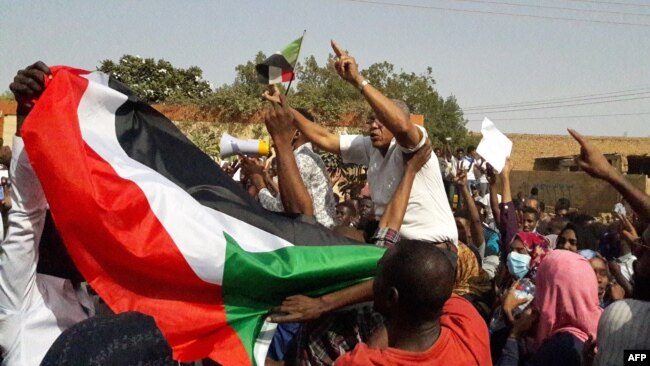 Sudanese protesters wave their national flag and chant slogans during an anti-government demonstration in the capital Khartoum's twin city of Omdurman on Jan. 31, 2019. 