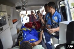 FILE - Members of an Indonesian medical team transport an earthquake survivor in an ambulance in Lombok, July 29, 2018.