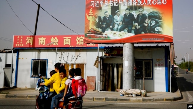 Hình ảnh Chủ tịch Tập Cận Bình nắm tay nhóm cao niên Uighur được treo tại một ngôi làng ở khu vực Tân Cương.