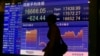 A man walks by an electronic stock indicator of a securities firm in Tokyo, April 28, 2016. 