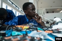 Aboubacar Savage, 14, from Gambia looks at a computer at the 2017 Pan-African Robotics Competition in Dakar, Senegal, May 19, 2017. (R. Shryock/VOA)