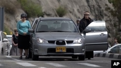 Israelis stand still beside their cars on highway as two-minute siren sounds in memory of Holocaust victims, Jerusalem, April 19, 2012.