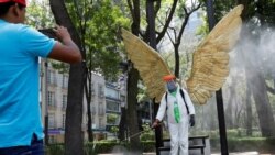 Un empleado mexicano, vestido con un traje protector antibacterial, posa para una fotografía en el Paseo de la Reforma de Ciudad de México.