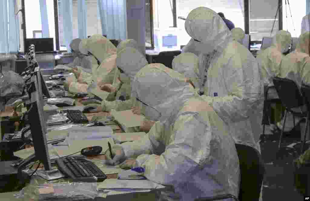 Central Election Commission officials dressed in white disposable overalls and wearing face masks count votes arrived from Serbia in Kosovo capital Pristina. Vote counting has been suspended after several commission officials reported health problems including allergic reactions and skin problems after opening ballot boxes from Serbia, authorities said.