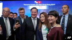 FILE - In this Tuesday, April 2, 2019, file photo, Panama's President Juan Carlos Varela Rodríguez, center, poses with his guests after a conference on the "Panama invest in Hong Kong." (AP Photo/Kin Cheung, File)