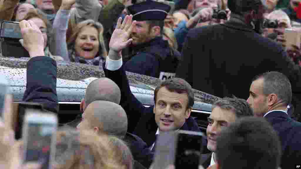 Le candidat de &quot;En marche!&quot; au second tour de l&#39;élection présidentielle, Emmanuel Macron, salue avant qu&#39;il quitte le bureau de vote.