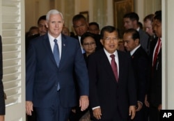 ຮອງປະທານາທິບໍດີສະຫະລັດ ທ່ານ Mike Pence, ຊ້າຍ, ຍ່າງກັບຄູ່ຕຳແໜ່ງອິນໂດເນເຊຍ ທ່ານ Jusuf Kalla (ຂວາ) ຫລັງຈາກກອງປະຊຸມ ທີ່ນະຄອນ Jakarta ປະທດ Indonesia.
