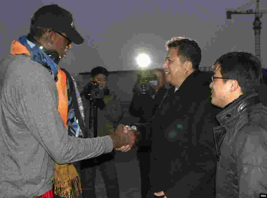 Former NBA basketball star Dennis Rodman shakes hands with Vice Minister of North Korea's Sports Ministry, Son Kwang Ho, as Rodman arrives at the international airport in Pyongyang, North Korea, Dec. 19, 2013.