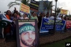 FILE - Activists of Pakistan civil society rally holding a picture of slain Kashmiri resistance leader Burhan Wani during an anti-Indian protest in Lahore, Pakistan, Aug. 2, 2016.