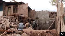 FILE - Pakistani villagers living at the Line of Control between Pakistan-Indian Kashmir, Chakoti, build concrete house in Pakistan, Nov. 21, 2016.
