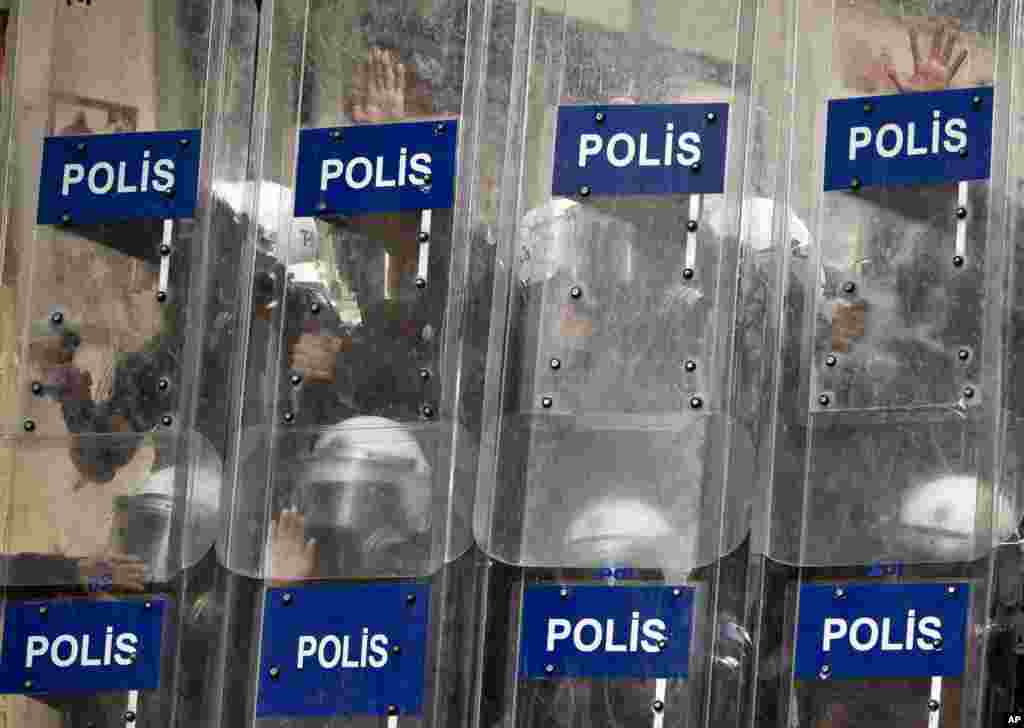 Riot police press their hands onto their shields during clashes in Istanbul, July 8, 2013.