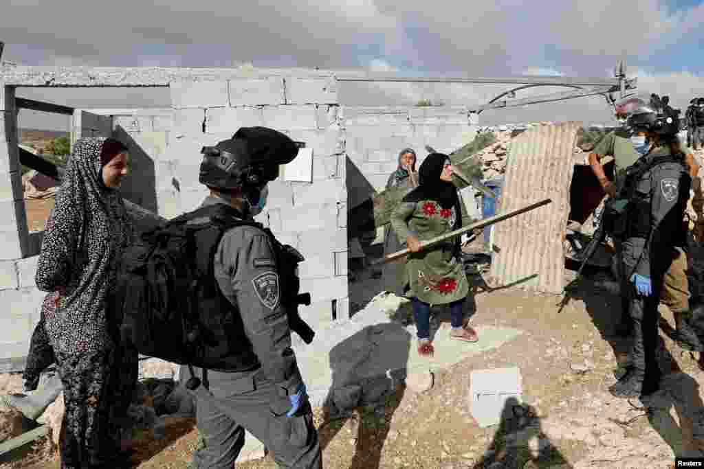 A Palestinian woman argues with Israeli border police officers who arrived to force her stop building a house, in Susya village in the occupied West Bank.