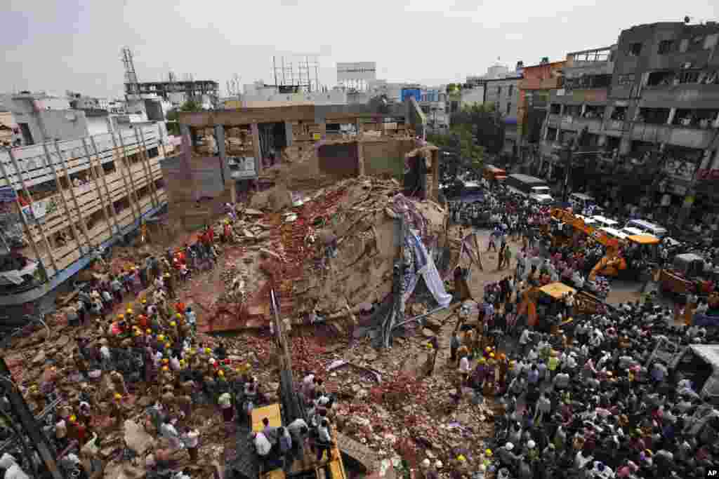 Fire officials and rescue workers look for survivors at the site of a collapsed building, in Secunderabad outside Hyderabad, India, July 8, 2013.