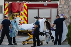 EMS workers pick up a suspected COVID-19 positive patient in the Rio Grande Historic District of El Paso, Texas on November 15, 2020.