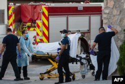 EMS workers pick up a suspected COVID-19 positive patient in the Rio Grande Historic District of El Paso, Texas on November 15, 2020.