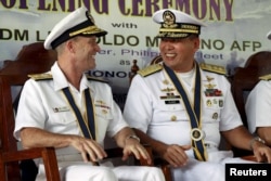 FILE - Philippine Navy Rear Admiral Leopoldo Alano (R) shares a light moment with U.S. Navy Rear Admiral William Merz during the opening ceremony of the Cooperation Afloat Readiness and Training (CARAT) 2015 at navy headquarters in Puerto Princesa city.