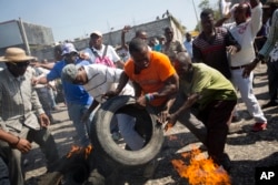 Protesters set tires alight during a street protest against President Michel Martelly's government in Port-au-Prince, Haiti, Jan. 18, 2016.