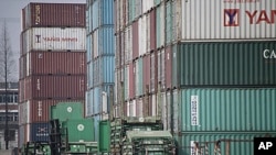 A forklift arranges the shipping containers near a port in Shanghai, China, March 2, 2011.