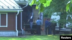 A still image taken from a video footage shows men loading a truck at a dacha compound used by U.S. diplomats for recreation, in Serebryany Bor residential area in the west of Moscow, Russia, Aug. 1, 2017.