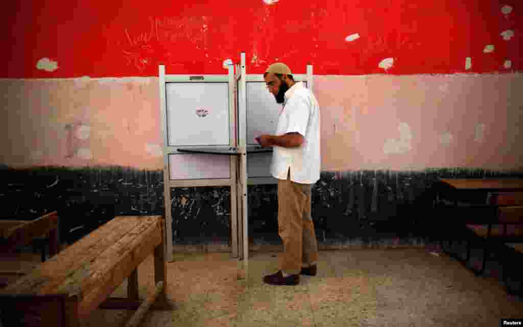 A voter prepares to cast his vote at a polling station in Cairo.