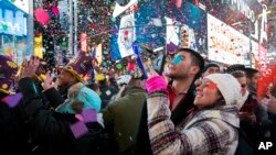 FILE - Confetti falls as people celebrate the new year in New York's Times Square, Jan. 1, 2017. 