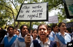 FILE - Indian students shout slogans as they hold placards demanding stringent punishment for rapists during a protest in New Delhi, India, April, 23, 2013.