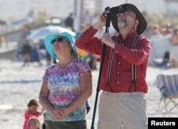 Spectators at Cocoa Beach watch SpaceX's first Falcon Heavy rocket launch from the Kennedy Space Center, Feb. 6, 2018.
