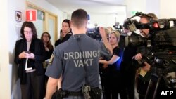 Un agent de sécurité se tient devant les journalistes lors de l'ouverture du procès de Rakhmat Akilov, devant le tribunal de Stockholm, le 13 février 2018.