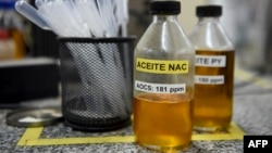FILE - Samples of soy oil and biodiesel at laboratory in Santa Fe province, Argentina, Sept. 13, 2017. From Brazil to Indonesia, the rush to cultivate biofuel crops has pushed farmers to switch from crops-for-food to more profitable crops-for-fuel.