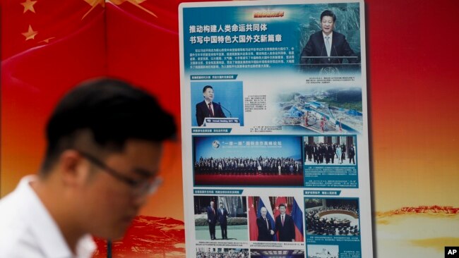 北京地铁外，一名男子走过宣传中国国家主席习近平提出的“一带一路”倡议的广告牌。(2018年8月28日)