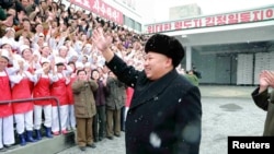 មេ​ដឹកនាំ​កូរ៉េ​ខាង​ជើង​ លោក Kim Jong Un កំពុង​បក់​ដៃ​ទៅ​កាន់​អ្នក​ធ្វើ​ការ​នៅ​រោងចក្រ​ Pyongyang Children's Foodstuff Factory កំឡុង​ពេល​ដែល​លោក​ទៅ​ធ្វើ​ទស្សនៈ​កិច្ច​នៅ​ទីនោះ។